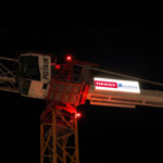 Vue globale de nuit de la LightBox Grue latérale installée sur les équipements de levage du chantier de Vaulx-en-Velin.