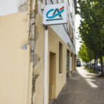 Enseigne drapeau lumineuse en saillie, élément clé de la signalétique d'agence bancaire à Lozanne.