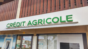 Enseigne lumineuse verte marquant l'entrée, dans le cadre de la signalétique d'agence bancaire à Saint-Paul-en-Chablais.