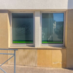 Zoom sur les fenêtres habillées d'adhésif dépoli ajouré pour la signalétique d'agence bancaire à Marcigny.