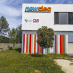 Vue de face de l'enseigne traditionnelle sur bardage blanc, élément central de la signalétique du site industriel Newcleo à Chusclan.