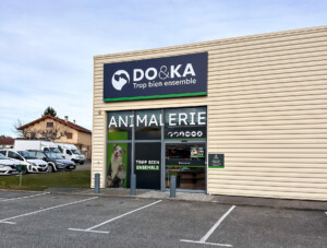Vue globale de loin de l'enseigne LightBox, de la vitrophanie et du panneau extérieur du magasin DO&KA à Chatte.