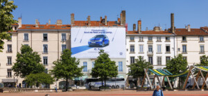 Vue lointaine de jour montrant l'intégration urbaine parfaite pour financer des travaux de façade à Lyon, place Bellecour.