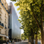 : Intégration urbaine parfaite de l'habillage de bâtiment Giorgio Armani au cœur des immeubles de l'avenue Montaigne à Paris.