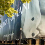 Détail de l'habillage de bâtiment au niveau du rez-de-chaussée assurant un accès élégant aux boutiques Giorgio Armani à Paris.