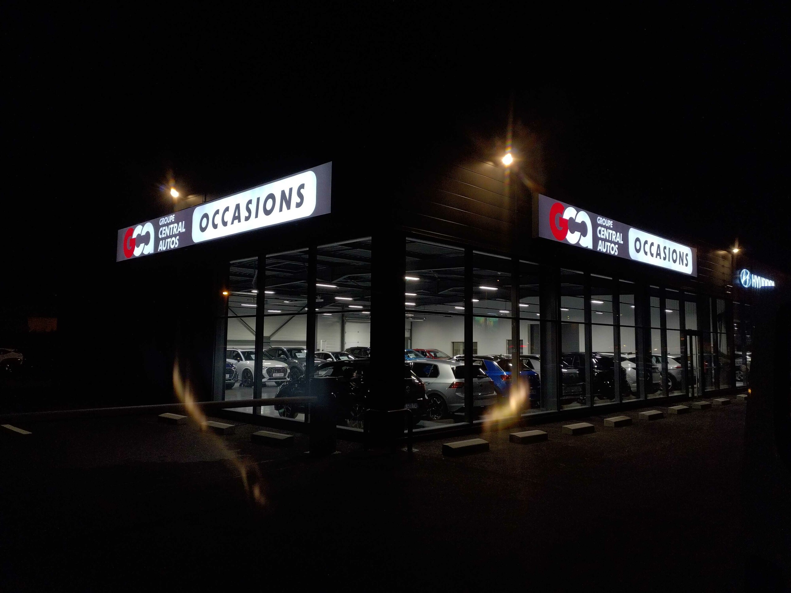 Enseigne LightBox lumineuse illuminée de nuit sur la façade du Groupe Central Autos