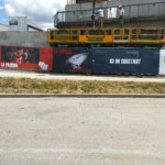 Palissade de chantier en toile imprimée avec slogans sur l'esprit d'équipe et la passion.