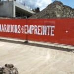 Palissade de chantier en toile rouge avec impression texte "Marquons notre empreinte" pour communication BTP.