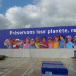 Façade industrielle avec toile tendue grand format « Préservons leur planète » sur l'enveloppe du bâtiment Paprec.