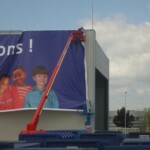 Installation sur nacelle d'un habillage publicitaire grand format sur l'enveloppe du bâtiment Paprec.